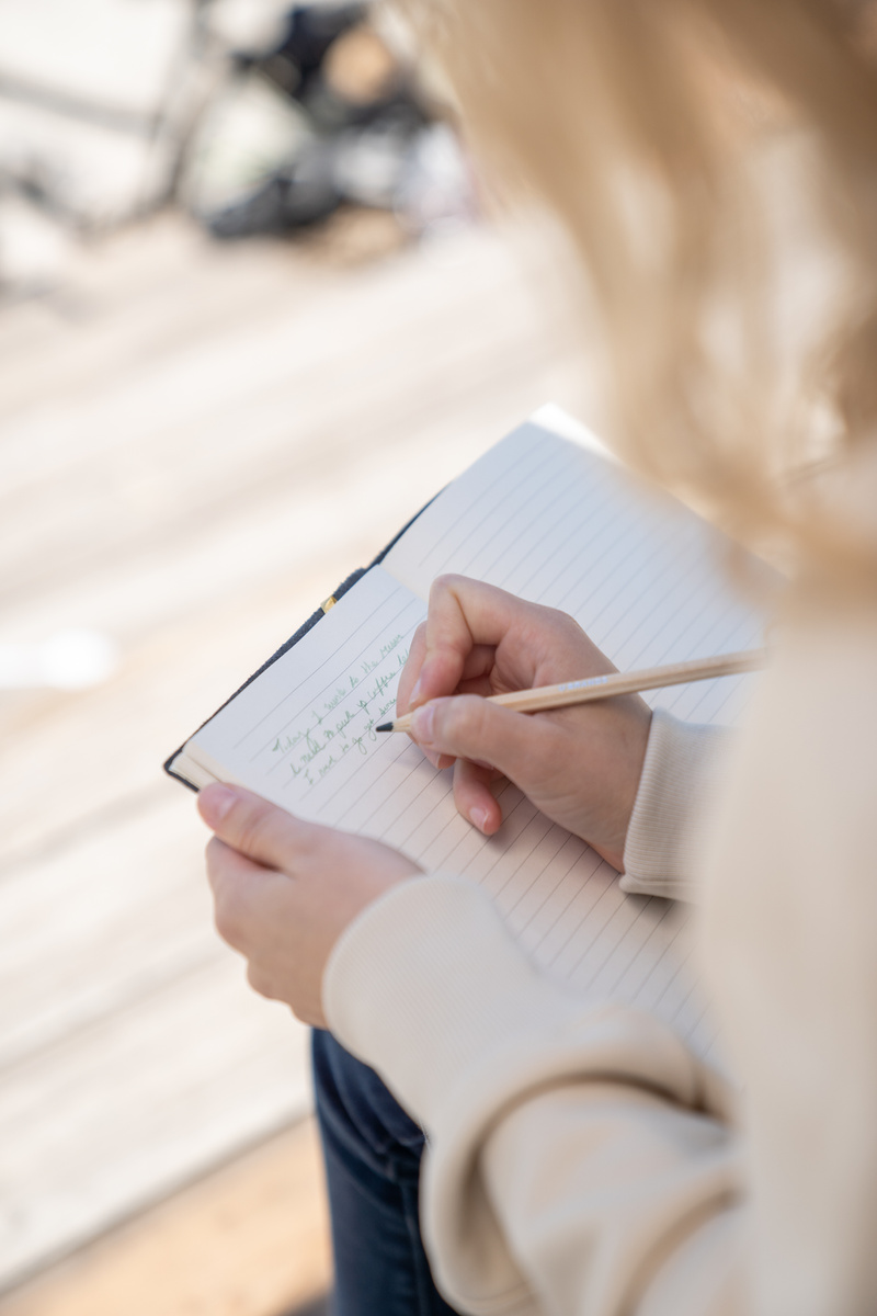 A Person Writing on a Journal